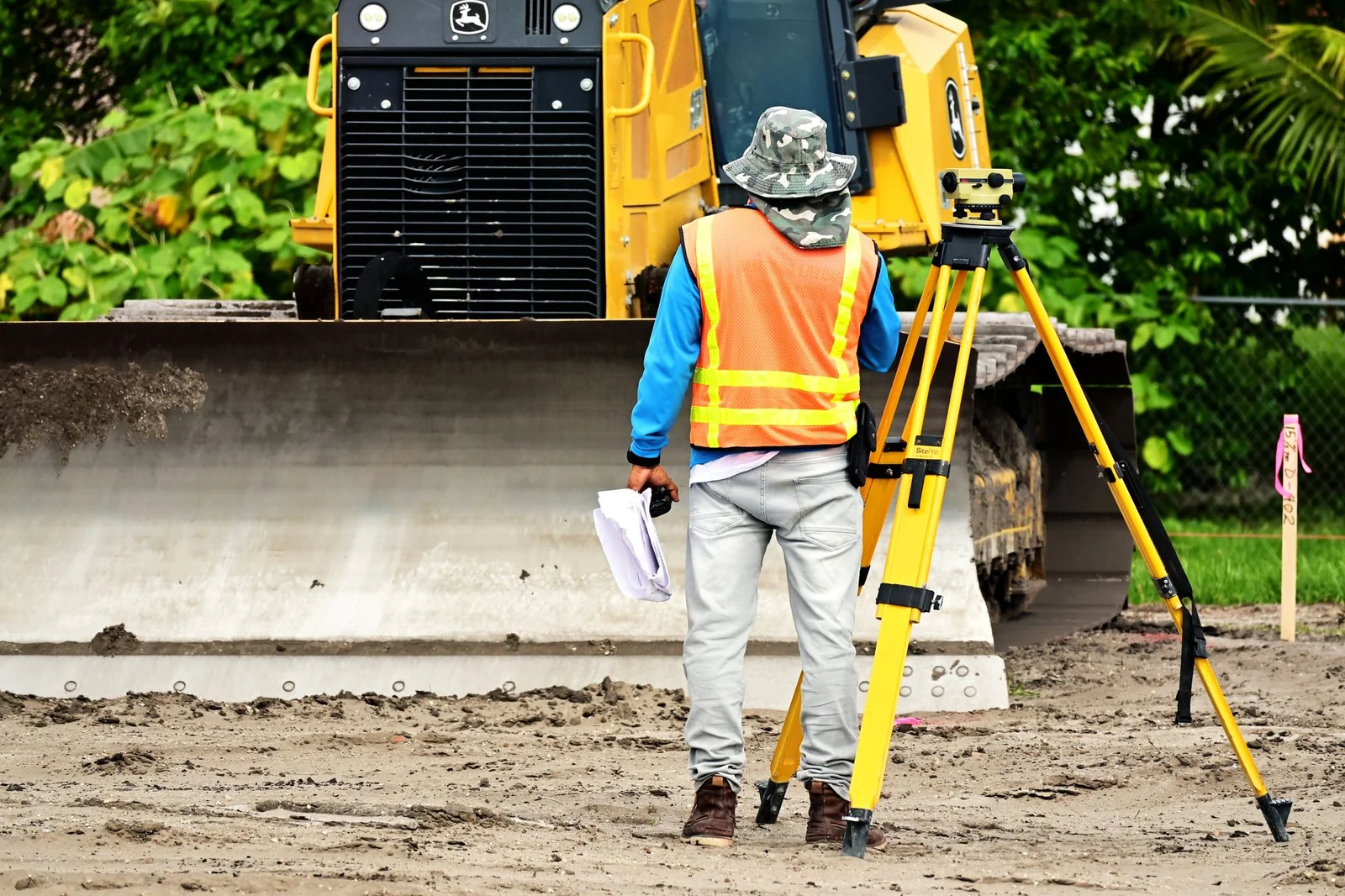 Géomètre effectuant un relevé topographique sur un chantier